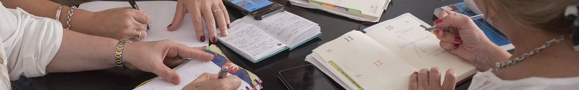 Manos de estudiantes, trabajando en cuadernos y papeles 