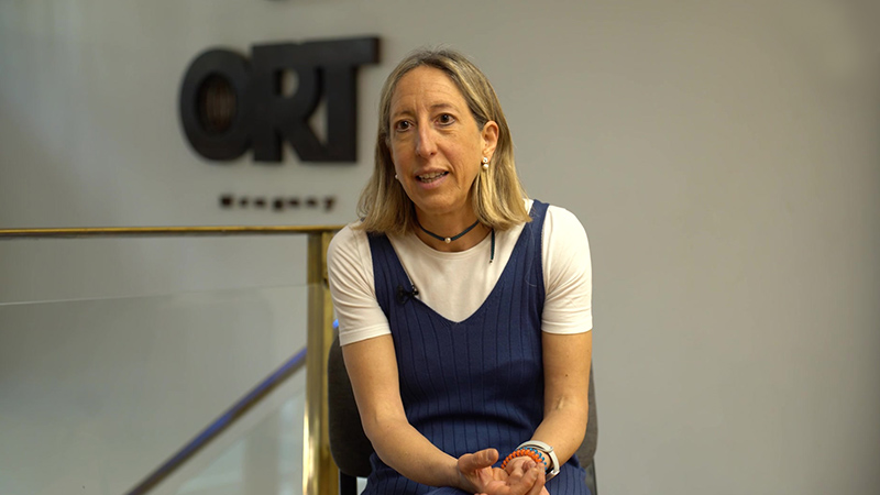 Anna Espasa sentada, con el logo de ORT en la pared detrás