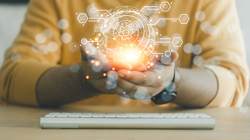 Manos con iconos que refieren a inteligencia artificial por encima